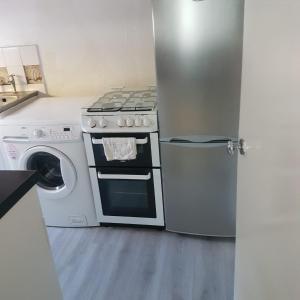 a kitchen with a stove and a refrigerator at Genesis place in Basildon