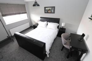 a bedroom with a bed and a desk and a chair at Executive Sea View apartment 3 Bedroom 'Lodge with the Legends' Sleeps up to 8 in Cleethorpes