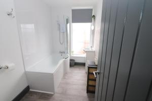 Executive Sea View apartment 3 Bedroom 'Lodge with the Legends' Sleeps up to 8 في كْليثوربس: حمام مع دش وحوض استحمام ومغسلة