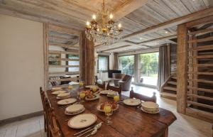 a dining room with a wooden table and a chandelier at Racca - Luxury chalet near ski lift in Chamonix