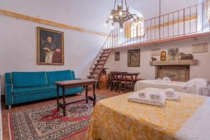 a living room with two beds and a blue couch at Palazzo Danesi in Montepulciano
