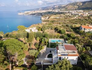 una vista aerea di una casa su una collina vicino all'oceano di La Dimora degli Angeli a Tropea