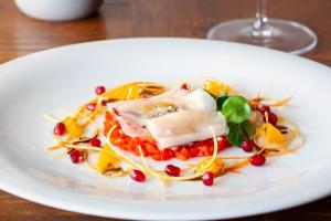 a white plate of food on a table at KABAJ Wine & Dine in Dobrovo