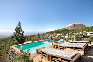 una piscina con mesas y una sombrilla en El cazador 2, en Granadilla de Abona