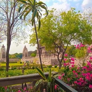 a view of a garden with flowers and a building at CHÉRI HOME Stay in Khajurāho