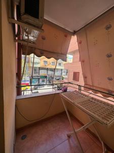 um quarto com uma varanda com uma mesa e uma janela em Cozy apartment at Sunny Hill em Tirana