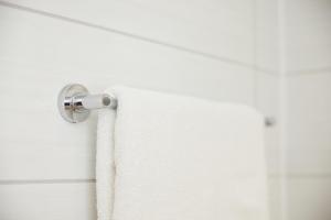 a white towel hanging from a shower curtain rod at The Quays by Greene King Inns in Northampton