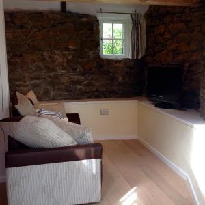 a living room with a couch and a television at The Blacksmith's Shop in Port Isaac