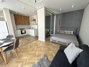 a bedroom with a bed and a table and a kitchen at Apartment 2, Podillya, новобудова in Vinnytsya