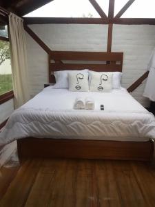 a bedroom with a bed with two towels on it at Tiny Celina House in Baños