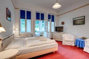 a bedroom with a bed and a tv and windows at Heringsdorf, Villa Lindemann W3 in Heringsdorf +8 photos