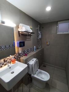 a bathroom with a white toilet and a sink at Double Nine Homestay - Sri Indah Condominium in Sandakan