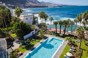 an aerial view of a resort with a pool and the ocean at OCEANO Health Spa Hotel in Punta del Hidalgo