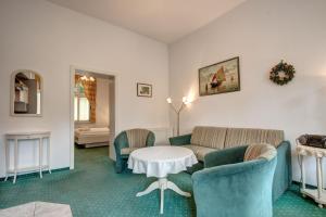 Una sala de estar con un sofá y sillas y una mesa. en Heringsdorf, Villa Lindemann W4, en Heringsdorf