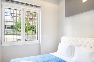 une chambre avec un lit et une fenêtre dans l'établissement Kazi Home 3, à Athènes