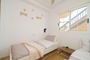 - une chambre blanche avec un lit et une fenêtre dans l'établissement Villamartin, à Villamartín