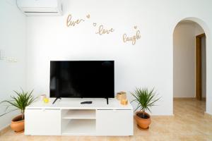 un salon avec une télévision à écran plat sur un mur blanc dans l'établissement Villamartin, à Villamartín