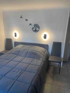 um quarto com uma cama azul e 2 cadeiras em Chez Pascal et Sonia au calme ! em Sevran