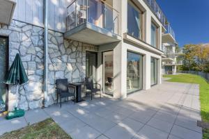 a patio with a table and chairs next to a building at Apart Invest Widok 800 M3 in Szklarska Poręba