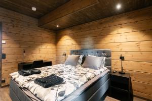 a bedroom with a bed with two bags on it at Luxury Villa Lapland in Rovaniemi