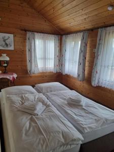 ボーデンマイスにあるHotel Pension Ankeの木造キャビン内のベッドルーム1室(ベッド2台付)