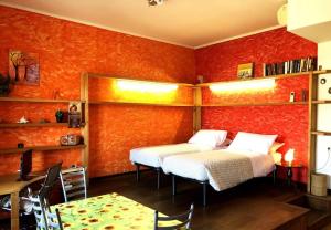 twee bedden in een kamer met oranje muren bij Porta Volta Flexyrent Studio in Milaan