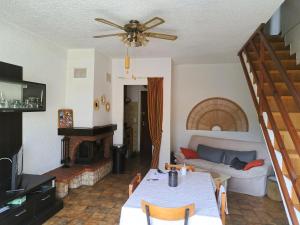 sala de estar con mesa y sofá en Mini villa jardin 50 m plage en Borgo