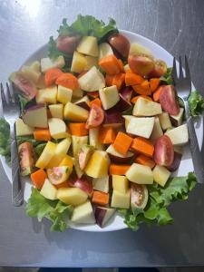 a plate of vegetables on a table with two forks at Himalaya Serene View Guest House & Farm Stay in Deorāli +204 photos
