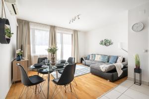 uma sala de estar com um sofá, uma mesa e cadeiras em Paulay Private Apartment em Budapeste