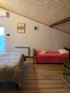Guests house Qotukner في Karbi: غرفة نوم بسريرين وبطانية حمراء