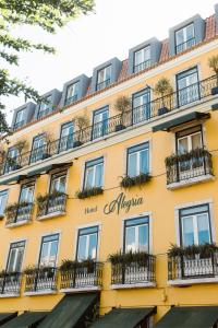 un edificio amarillo con ventanas y balcones en Alegria A Lisbon Boutique Hotel, en Lisboa
