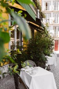 uma mesa com uma toalha de mesa branca num pátio em Alegria A Lisbon Boutique Hotel em Lisboa