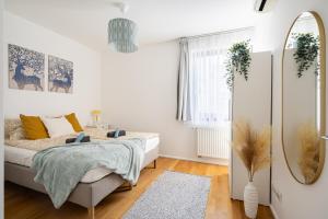 biała sypialnia z łóżkiem i lustrem w obiekcie Paulay Private Apartment w Budapeszcie