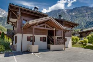 a house with a balcony and mountains in the background at Amethyste - 2 Bedrooms & Free Parking - By Cozee Rentals in Les Houches