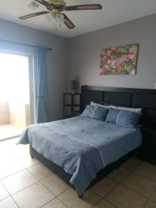 a bedroom with a large bed with a ceiling fan at Afsaal Sea view apartments in Amanzimtoti