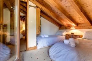 2 bedden in een kamer met houten plafonds bij Apartment Amethyste 2 Bedrooms with Free Parking in Les Houches