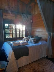 a bedroom with a bed in a wooden room at Cabana Van Gogh in Campo Alegre