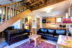een woonkamer met leren banken en een tafel bij Apartment Amethyste 2 Bedrooms with Free Parking in Les Houches