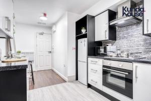 uma cozinha com electrodomésticos brancos e uma parede de tijolos em Cosy Apartments - City Living Made Elegant - em Birmingham