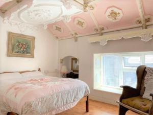 a bedroom with a bed and a chair and a ceiling at Cosy & Comfy in Kinvara