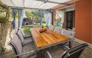 una mesa de madera y sillas en un patio en Nice Home In Buje With Wifi en Buje