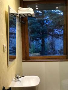 baño con lavabo y ventana con árbol en Hotel Vallibierna en Benasque