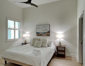 a white bedroom with a bed with two lamps at 365 Cinnamon Beach in Palm Coast