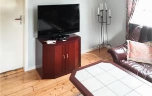 sala de estar con TV de pantalla plana en un soporte de madera en 2 Bedroom Nice Home In senhga en Åsenhöga