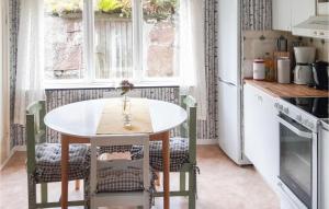 a kitchen with a table and chairs in a kitchen at Stunning Home In senhga With 2 Bedrooms And Wifi in Åsenhöga