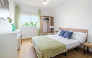 ein Schlafzimmer mit einem Bett mit blauen Kissen und einem Fenster in der Unterkunft 4 Bedroom Nice Apartment In El Campello in El Campello