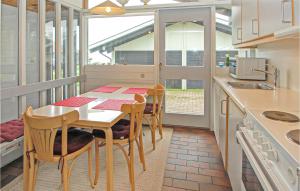 uma cozinha com uma mesa e cadeiras e um lavatório em Golfparken em Løjt