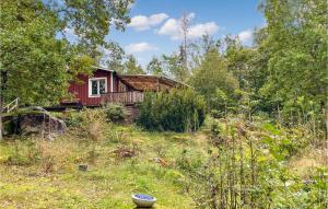 una cabina rossa in mezzo a una foresta di 3 Bedroom Stunning Home In Gullspng a Gullspång