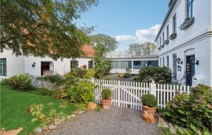 una cerca blanca frente a una casa blanca en Gorgeous Apartment In Svaneke With House Sea View, en Svaneke