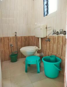 a bathroom with a toilet and a sink and buckets at A Latent Farm stay in Gimvi